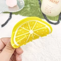 Bright yellow lemon shaped acrylic hair claw clip held in hand for size visualization - Orange