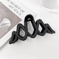 Haarklammer in Matt-Schwarz mit Wellendesign auf einem minimalistischen Hintergrund - Doppel-M Schwarz 10cm
