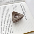 Pince à cheveux triangle marron café mat posée sur la page d'un livre français - Type E Café 4.5cm