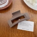 Minimalistische rechteckige hohle Haarklammer in Matt-Dunkelkakao auf einem Holztisch - Quadrat Braun 8.8cm