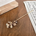 Pasador de pelo dorado con hojas de ginkgo y perlas sobre fondo de madera - Rama de Ginkgo Oro (15cm)