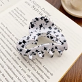 Elegant heart hair claw clip with black star pattern on a book for chic styling - Star