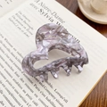Elegant heart-shaped hair claw clip in purple marble acetate on a vintage book - Dusty Pink