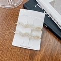 Elegant set of two cream acetate wavy hair clips with gold label on wooden display - 7cm / Cream Floral