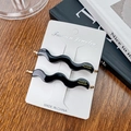 Pair of elegant black wavy acetate hair clips with gold metal tips on a display card - 7cm / Black