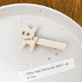 Creamy cat-shaped acetate hair clip with sparkling rhinestones in a ceramic dish - Milk White