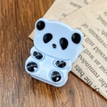 Süße hellblaue Panda-Haarklammer aus Acetat auf antikem Zeitungs-Hintergrunddesign - Himmelblau