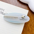 Fermaglio ovale in acetato celeste con strass e dettaglio dorato sorridente - 6.3cm / Celeste