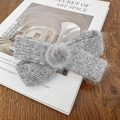 Fermaglio per capelli con fiocco in maglia grigia e pompon morbido su un libro d'arte - 10.5cm / Grigio