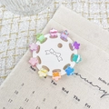 Set of 10 colorful mini flower hair claws in macaron tones on a white card display - Flower Shape