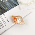 Pinza para el pelo de acetato con forma de concha naranja y detalle de perla - Caracola Pequeña