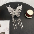 Elegante pinza de pelo de mariposa plateada con borlas largas de metal sobre fondo oscuro - Estilo Mariposa Borla Nudo Chino / Plateado