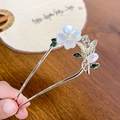 Horquilla en U dorada con pétalos blancos, hojas verdes y detalle de mariposa fina - Trébol de cuatro hojas de jade blanco