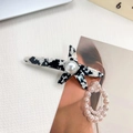 Pinza para el pelo de acetato marmoleado blanco y negro con una gran perla central - Patrón de Vaca