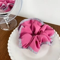 Elegante elastico scrunchie rosa con bordi a righe su un piatto di ceramica bianca - A Righe Rosso con Bordo a Gonna