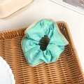 Elegante blauw-groen gestreepte satijnen scrunchie in een rustieke gevlochten mand - Gestreepte Groen