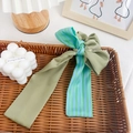Chouchou élégant vert sauge avec ruban à rayures sur un plateau de décoration - Ruban à Nœud Vert