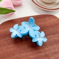 Light blue flower claw clip with triple-petal design in matte finish on wood tray - Blue 9.5cm