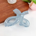 Light blue translucent resin hair claw clip with interlocking design on wooden tray - Blue (Twist Style)