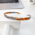 Minimalistisches Acetat-Haarband mit orange-blauem Marmormuster auf Display - Cremiger Kaffee
