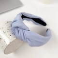Light blue knotted fabric headband with a wide cross design on a ceramic cup - Sky Blue