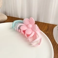 Eleganter Blumen-Haarclip mit pink-blauem Farbverlauf auf weißem Keramikteller - Blumen-Haarklammer