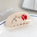 Elegante haarklem van crème acetaat met rode roospatronen op een porseleinen bord - Halve Cirkel Roos