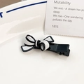 Barrette à cheveux nœud en acétate noir et blanc avec finition polie sur fond blanc - Nœud Croisé Blanc