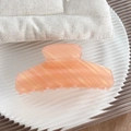 Orange pink hair claw clip with pearlescent marble texture on a white striped tray - Striped Pink Coffee