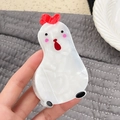 Graziosa pinza per capelli a forma di gallo bianco in acetato mostrata a mano - Gallina Bianca