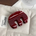 Pinza per capelli a zucca rosso scuro lucido in formato medio su tessuto beige - Rosso