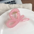 Elegant jelly pink translucent hair claw clip with gold spring on a ceramic plate - Bow