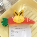 Niedliche Haarspange in Karottenform mit grünen Blättern und einem gelben Hasenakzent - Hase und Karotte