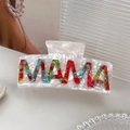 White acetate floral hair claw clip featuring colorful MAMA letters on a modern table - MAMA White Floral