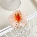 Translucent pink resin frangipani hair clip with orange gradient on white mesh stand - Orange