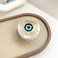 Blue Evil Eye round acrylic hair clip with pearl texture on a beige leather background - Evil Eye Type 1