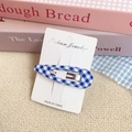 Blau-weiße Gingham-Stoff-Haarspange auf Displaykarte mit sanftem rosa Buchhintergrund - Blau Kariert