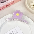 Lavendelfarbene Blumen-Haarklammer mit gelber Mitte in einer Keramikschale - Lila Blume