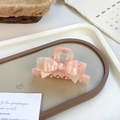 Pink marble texture acetate bow hair claw clip for women on a grey display tray - Light Pink