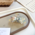 Pastel marble acetate bow hair claw clip with colorful patterns on a cream tray - Rainbow