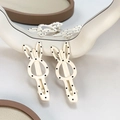 Paire de pinces à cheveux lapin crème à pois noirs sur support d'exposition épuré - Lapin Blanc à Pois
