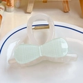 Medium cream resin hair claw with light green checkered bow on a white porcelain plate - Fresh Green Plaid Bow