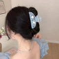 Blue ocean-style hair claw clip with starfish and seashell charms on model's dark hair - Arc Starfish