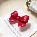 Elegant bright red acetate bow hair clip with gold metal base on a white card - Red