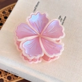 Dettaglio della pinza per capelli a fiore rosa perlato con bordi bianchi su un libro - Fiore Perlato Viola (27818C)