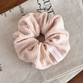 Close-up of light pink corduroy scrunchie showing ribbed texture and brand label detail - Pink Scrunchie (24309A)