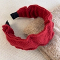 Gros plan d'un serre-tête en tricot rouge à volants avec une texture de laine douce - Rouge