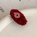 Detail view of red chenille hair clip with golden pendant featuring traditional text - Daily Rich Duckbill Clip