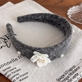 Dettaglio del cerchietto in lana grigio scuro con fiore di camelia bianco e decori di perle - Grigio