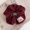 Detalle de coletero de tela a cuadros rojos con etiqueta de cereza sobre lino vintage - Estilo de Cuadros